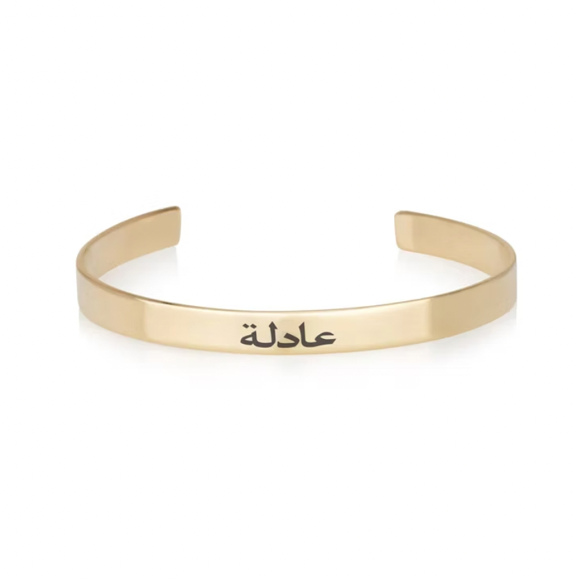 Gold bracelet with Arabic text on a white background. Engraved Arabic Name Bangle, gold, silver, rose gold, plated, 18k, plated. gold. silver. rose gold. plated 18k solid sterling silver. makana jewellery jewelry