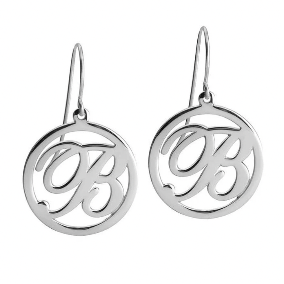 A pair of sterling silver drop earrings featuring circular cutout designs with an interlocking script  monogram.gold, sterling silver, rose gold, 18k, 20k. plated, makana jewellery, jewelry