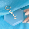 A silver metal keychain with a custom Arabic nameplate charm. Gold, Gold plated, Rose Gold, Sterling silver 925, 18k 20k. makana jewellery,  jewerly