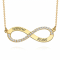 A gold infinity necklace with clear pavé stones along the lower curve and the names. Diamond, sterling silver 925, gold plated, rose gold plated. makana jewellery, jewelry