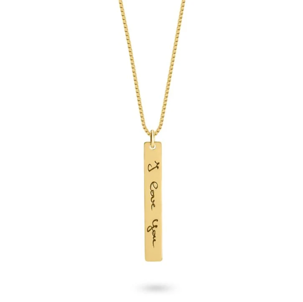 A gold bar pendant necklace engraved with 'I Love You' in black script, suspended from a gold chain. Rose gold, sterling silver, plated, makana jewelry, jewellery. gold