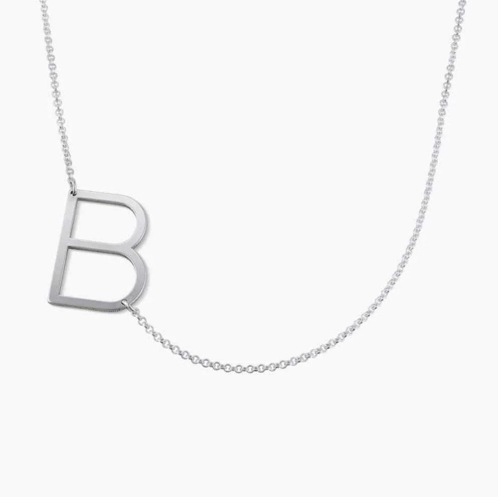 Silver necklace with a letter pendant on a white background. Rose gold, sterling silver, plated, makana jewelry, jewellery. gold
